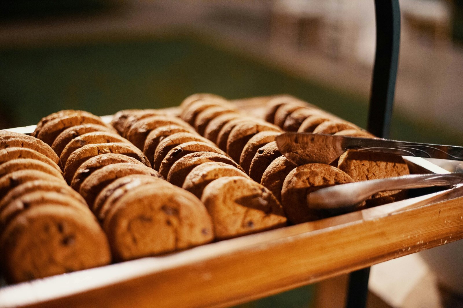 Close-up of freshly baked chocolate chip cookies on a wooden tray, indoors.